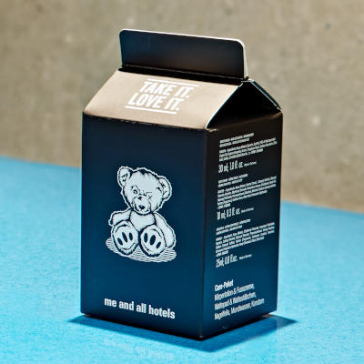 Foto: Care-Paket (Gesichts-Lotion, Nagelfeile, Kondom etc.) mit Zeichnung eines mitgenommenen Teddybären